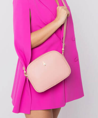 Modelka w fuksjowej sukience z różową torebką damską